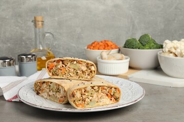 Pieces of delicious strudel with chicken, vegetables and products on light grey textured table, closeup