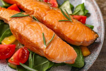 Healthy meal. Tasty grilled salmon with vegetables and spinach on table, closeup