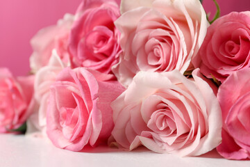 Bouquet of beautiful roses on light table, closeup