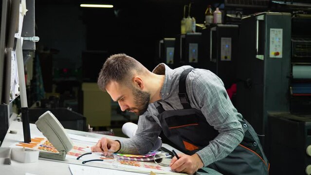 Graphic designer choosing colors from color palette. Concept of color management in the print production process