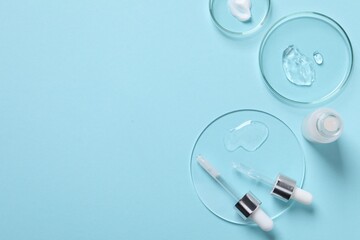 Petri dishes with samples of cosmetic serums, bottle and pipettes on light blue background, flat...