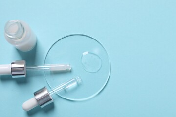 Sample of cosmetic serum, bottle and pipettes on light blue background, flat lay. Space for text