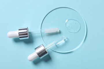 Sample of cosmetic serum and pipettes on light blue background, flat lay
