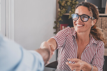 Smiling caucasian female hr manager handshake hire male candidate at job interview make good first impression, happy mixed race client shake hand of bank broker, respect, business agreement concept.