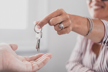 Crop close up of realtor give keys to man buyer or renter buying first home from agency. Real estate agent or broker congratulate male tenant with house or flat purchase. Ownership, rental concept.. - obrazy, fototapety, plakaty