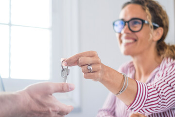 Crop close up of realtor give keys to man buyer or renter buying first home from agency. Real estate agent or broker congratulate male tenant with house or flat purchase. Ownership, rental concept.. - obrazy, fototapety, plakaty