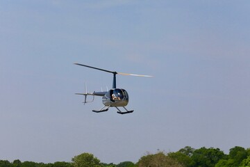 Low flying helicopter hovering over the trees