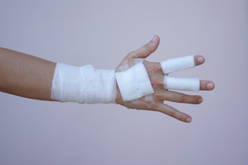 Asian and African male hands with elastic bandages on white background. Wrist wound, bandage, hand wound, painkiller