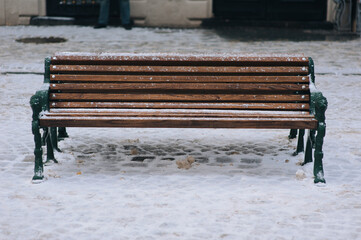 One wooden bench in the snow in the center of Lviv. Ukrainian winter.