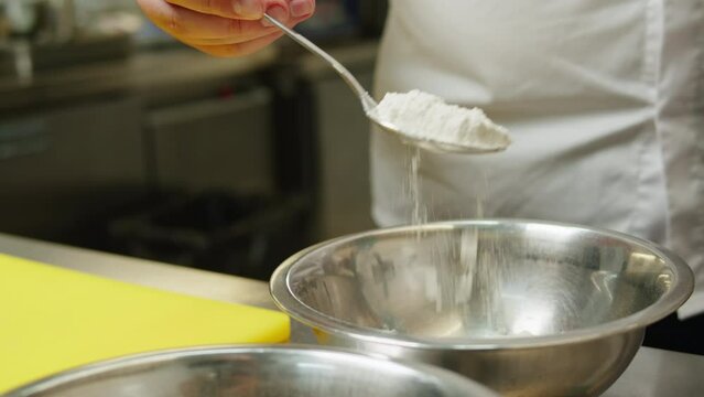Professional kitchen. Chef doing some dough with eggs and flour close-up, pastry head- chef, backery