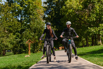 Obraz premium A blissful couple, adorned in professional cycling gear, enjoys a romantic bicycle ride through a park, surrounded by modern natural attractions, radiating love and happiness