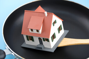 Using a spatula to stir fry a house in a flat bottomed pan