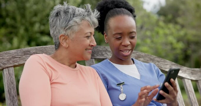 Senior, woman and caregiver with phone in nature with communication, laughing and happiness for meme. Elderly, black people and nurse with smartphone on swing with social media and internet joke