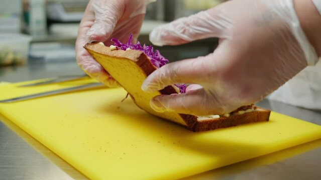 Chef cooking Katsu Sando japanese sandwich with breaded beef or pork chop, cabbage and tonkatsu sauce, traditional Japanese cuisine in restaurant.