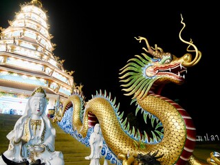 Fototapeta premium Dragon on Metal Incense Burner behind the Guanyin Goddess, A lot of incense sticks burning inside giant bronze incense burner on blurred background, Guanyin statue in the temple