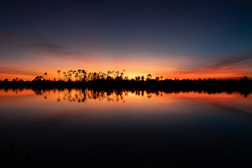 Beautiful vibrant sunset reflection at pond in Bonita Springs, Florida