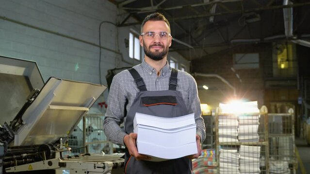 Portrait of print worker with paper for printing