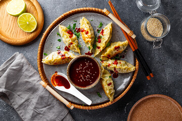 Asian dumplings with hot sauce on the grey background top view - obrazy, fototapety, plakaty