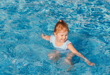 Fototapeta na wymiar Little girl having fun in swimming pool.