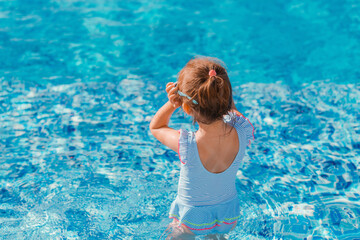 Little girl having fun in swimming pool.