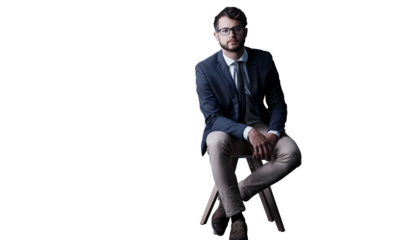 Portrait, serious and business man on chair isolated on a transparent png background in Spain. Glasses, professional entrepreneur in suit and confident salesman, worker and corporate employee career