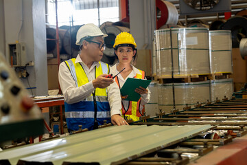 Factory engineer manager collaborate with coworker to conduct quality control on metal sheet...