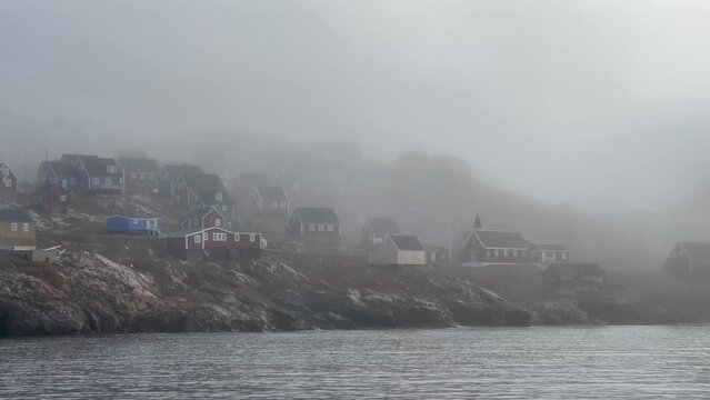Ittoqqortoormiit view with local church in a foggy morning. Scoresbysund, Greenland.