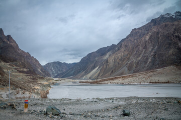 Valley between mountains on a cloudy day. A Dried river trains of Shyok river in Nubra Valley in Ladakh Region of Indian Himalayan territory .A  Barren landscape of Cold dessert in Himalaya Valley .