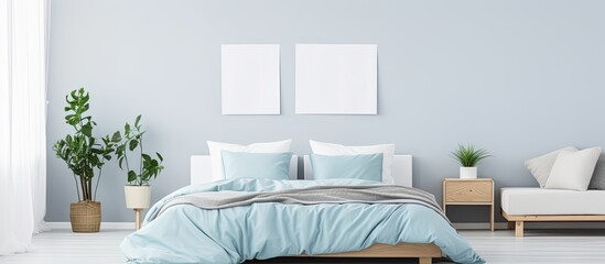 Blue bed with white pillows, duvet, and duvet case. White bed linen on blue sofa. Bedroom with bed, bedding, and poster frame mock up on wall. Left side view.