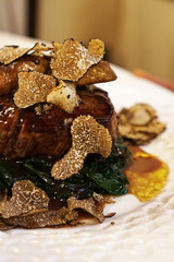 Close up Beef steak filet served with sauteed spinach, port sauce, Foie Gras and sliced black truffle