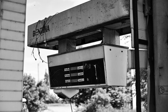 Old run-down gas station with gas pumps as a lost place in Wallachia in Romania in black and white