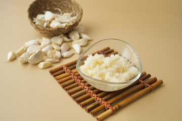 close up of minced garlic on a wooden spoon 