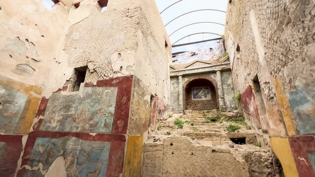 A haunting corridor in Pompeii with well-preserved ancient frescoes depicting Roman life, evoking the rich cultural history of this once-bustling city.