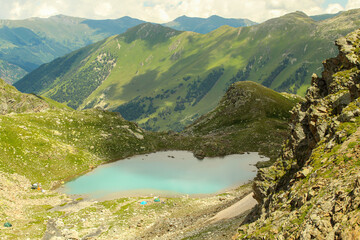 Close up on the small Sophia lake with camps on bank. Arkhyz, Caucasus, Russia