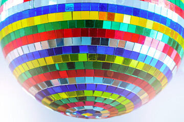 Fototapeta premium Disco ball with colored glass mirrors in selective focus.Close-up.Taken in backlit and sun glare.