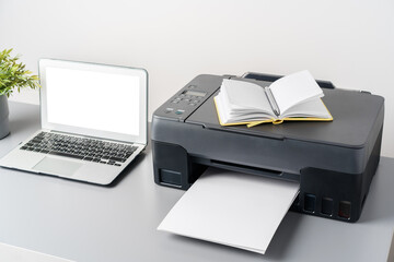 New modern printer and laptop in the office on table