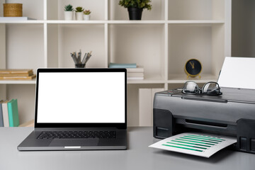 New modern printer and laptop in the office on table