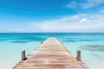 Fototapeta na wymiar A wooden pier or jetty heading toward the horizon on a crystal clear sea water beach