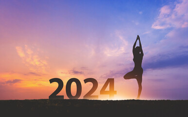 New year 2024 fitness healthy woman yoga with sunset sky background - obrazy, fototapety, plakaty