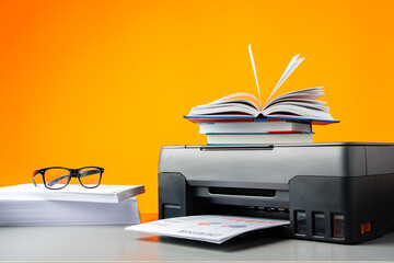 Laser printer on desk against yellow background.