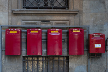 Bright red mail boxes lined up outside an Italian post office

