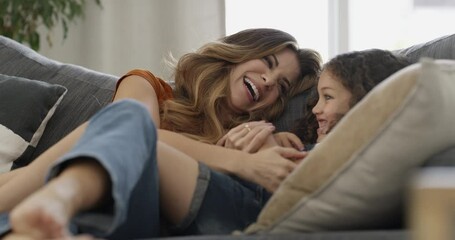 Mother, child and conversation on couch, happy and bonding at home, smile and communication. Mom, daughter and talking or hug, love and connection or trust, laughing and relaxing together in lounge