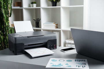 New modern printer and laptop in the office on table