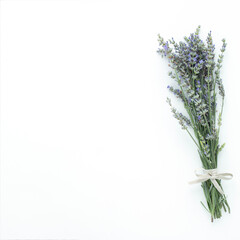 Flatlay of a fresh english lavender bouquet with linen ribbon bowtie on white background with copy space