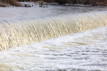 Waterfall on the river in winter as a background