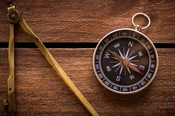 Vintage drawing and navigational Compass on a rustic wooden board