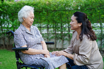 Fototapeta premium Doctor help Asian elderly woman disability patient sitting on wheelchair in park, medical concept.