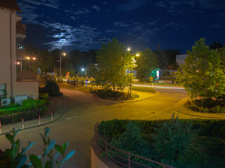 Evening street illuminated by moonlight and street lighting