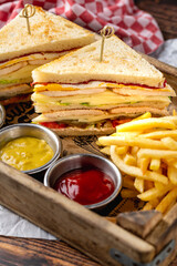 Chicken club sandwich with fries, ketchup, mustard and mayonnaise