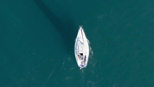 Top shot of sailboat floating in Pacific Ocean , Santa Barbara, California, USA. Birds eye view of yachts sailing in marina. Small boat surrounded blue deep waters of sea. Travel concept, 4k footage
